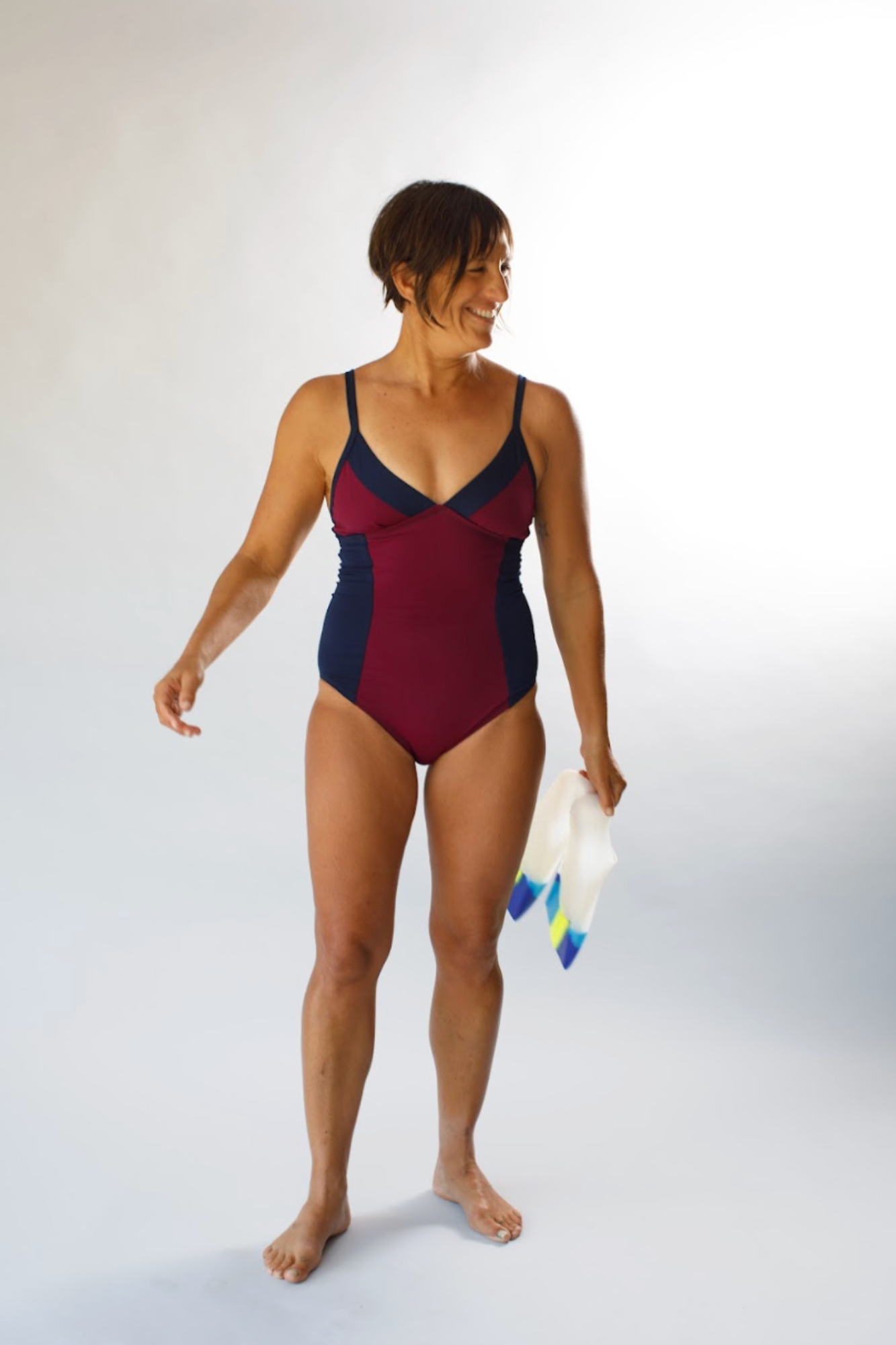 Woman wearing a red and navy swimsuit on a white background