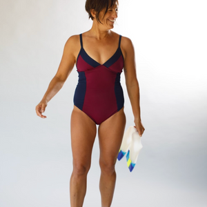 Woman wearing a red and navy swimsuit on a white background